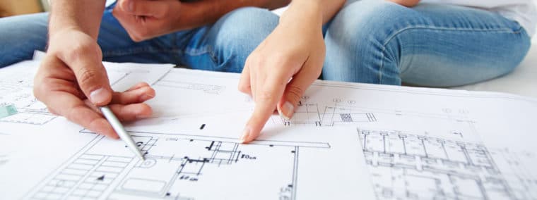 Two people pointing at an architectural plan, only hands visible