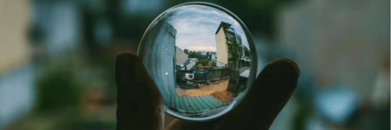 A crystal ball is visible in the image, and through it, you can see a city.