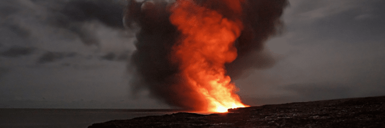 A photograph of a landscape with a fire burning and smoke rising from it.